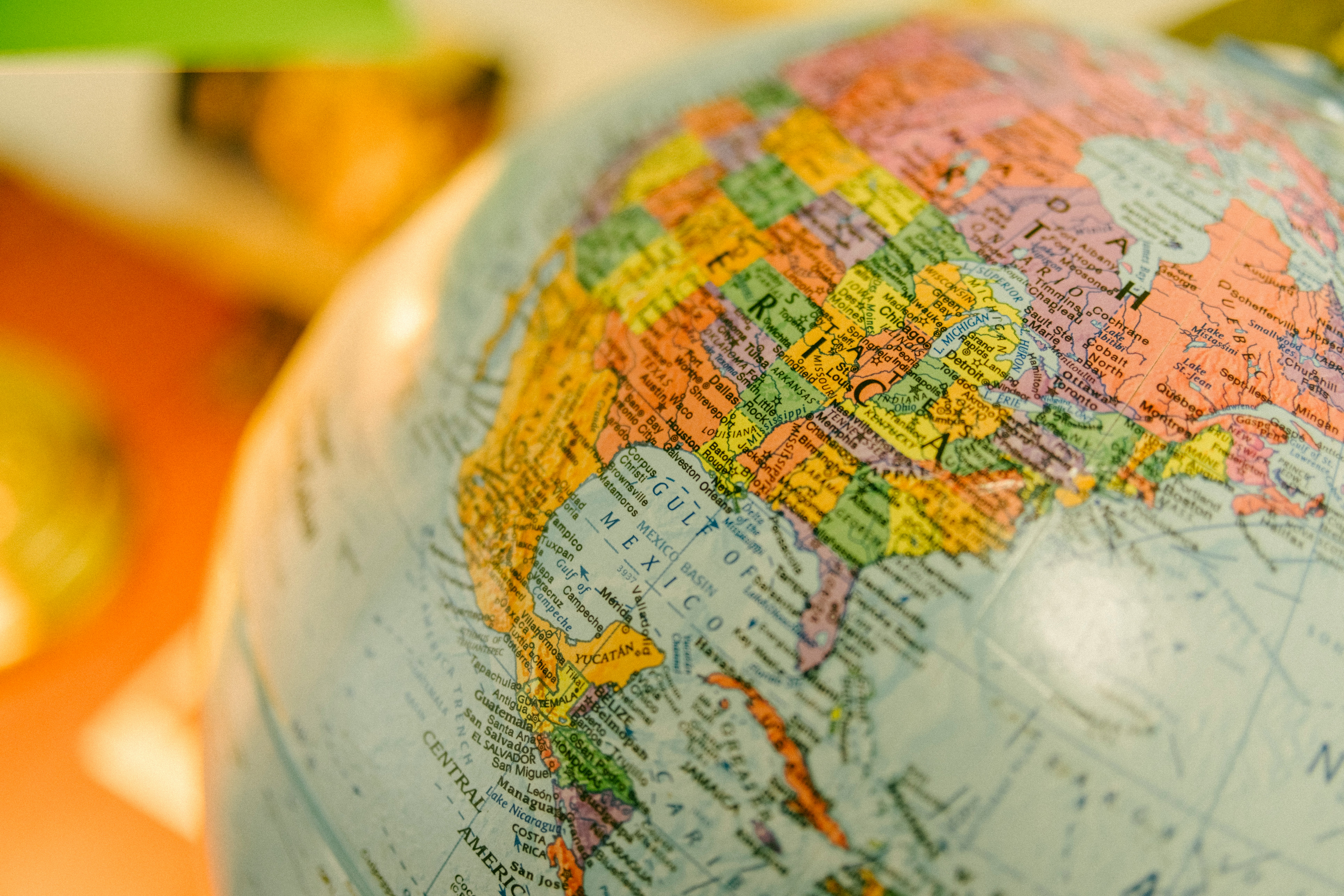 Close-up of a colorful globe showing North America, including the United States, Mexico, and nearby ocean areas. The image conveys exploration and curiosity.